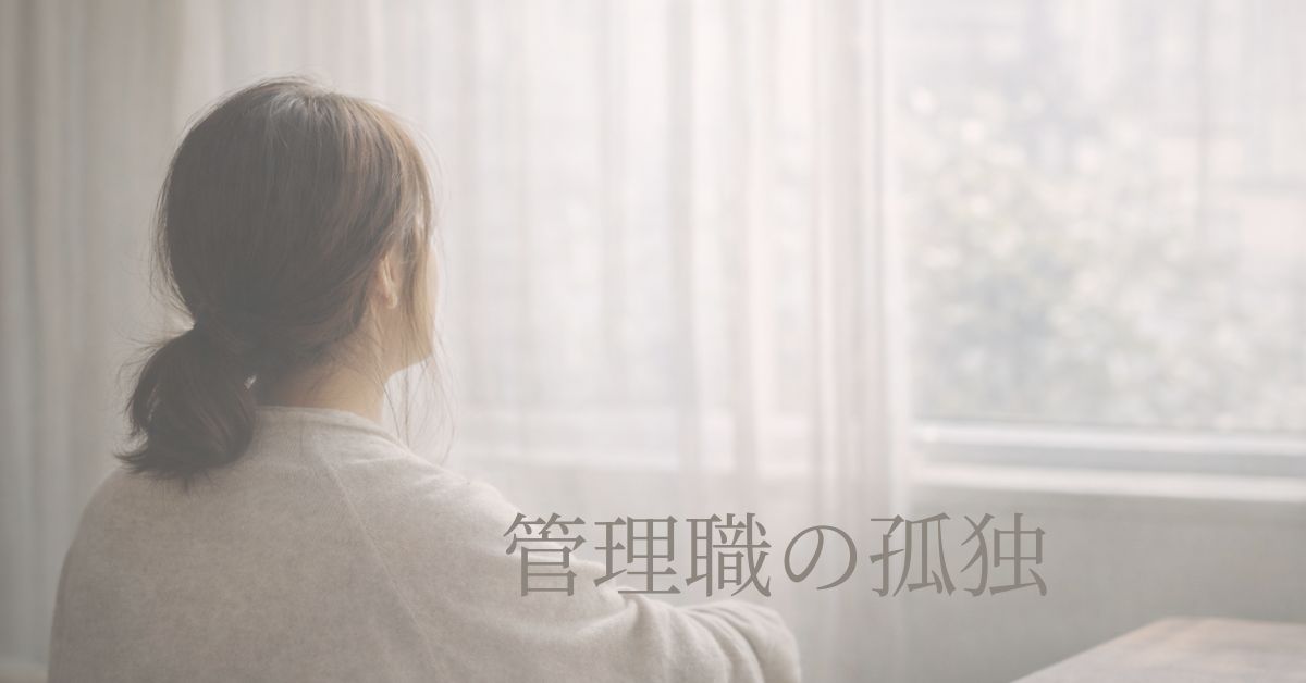 窓辺に立つ女性の後ろ姿。静かな室内の写真